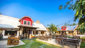 A courtyard with wooden benches and a sign reading "60s Town." - 60s Town (Hua Hin)