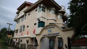 A multi-story building with a sign reading "Catarman Coral Dive Resort". - Coral Dive Resort (Catarman)