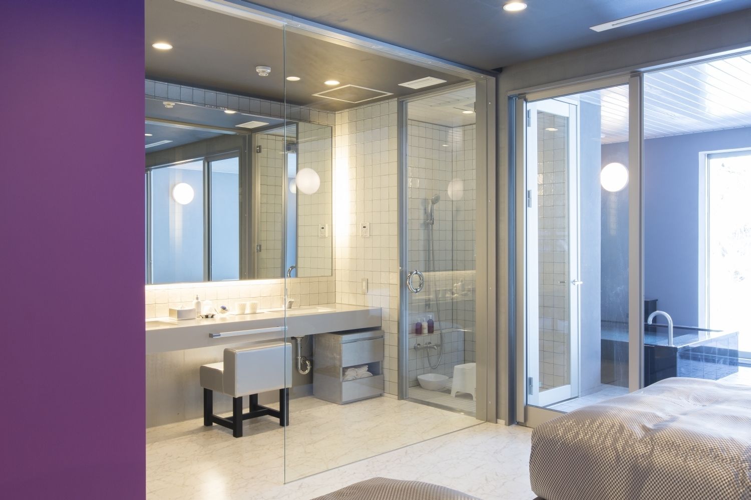 Un bagno moderno con doccia vetro, uno specchio grande e un lavabo con portasciugamani.