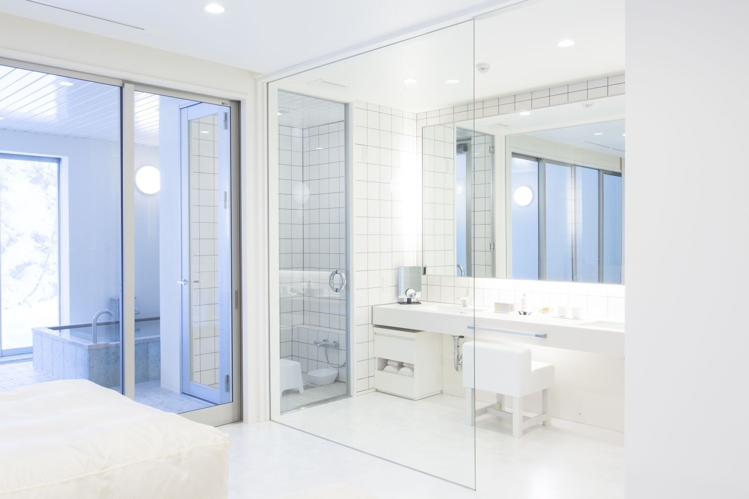 A modern bathroom with a glass-enclosed shower, a white sink, and a large mirror.