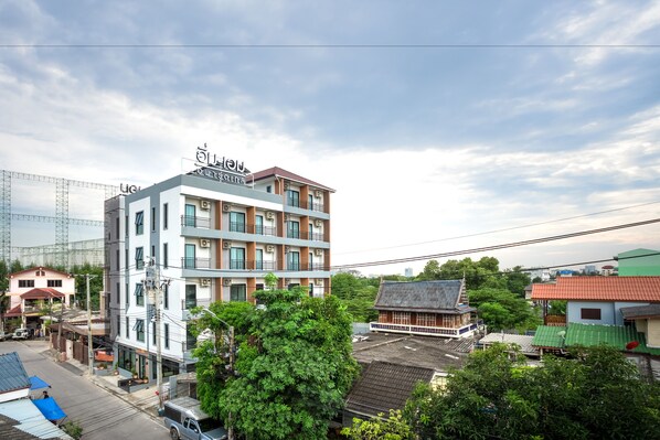 Un hotel de varios pisos con diseño moderno, con balcones y una señalización llamativa.