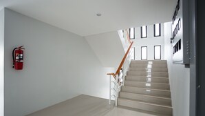 Um interior moderno com escada, extintor de incêndio e design minimalista e limpo.