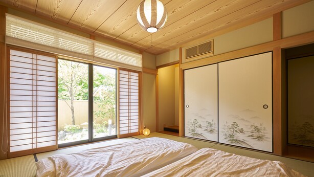 A traditional Japanese room with tatami flooring, sliding doors, and a bed with white bedding. - Nijo Fukuro-Tei (Kyoto)