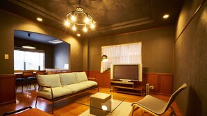 A modern living room with a sofa, a glass coffee table, a TV, and a chair. - Nijo Fukuro-Tei (Kyoto)