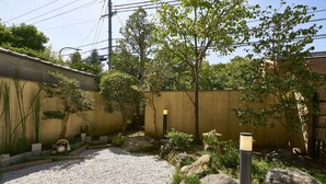 A gravel courtyard with rocks, a small tree, and a lamp post. - Nijo Fukuro-Tei (Kyoto)
