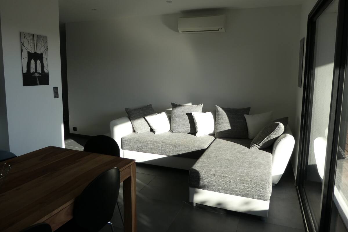 Een moderne woonkamer met een bank, een houten tafel en een schilderij aan de muur.