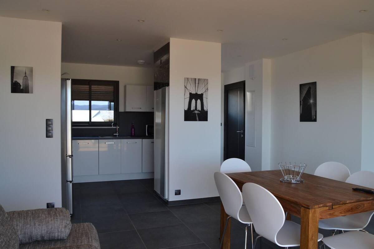Een moderne keuken met witte kastjes en een groot raam.