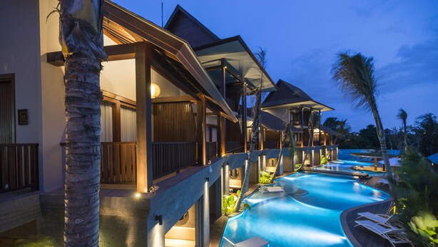 A resort with a swimming pool, wooden deck, and lounge chairs. - Sense Canggu Beach Hotel (Pererenan)