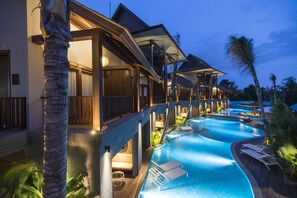 A resort with a swimming pool, wooden deck, and lounge chairs. - Sense Canggu Beach Hotel (Pererenan)