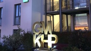 Un edificio de hotel con un letrero que dice "HOTEL" y una gran señal iluminada que dice "GMK".