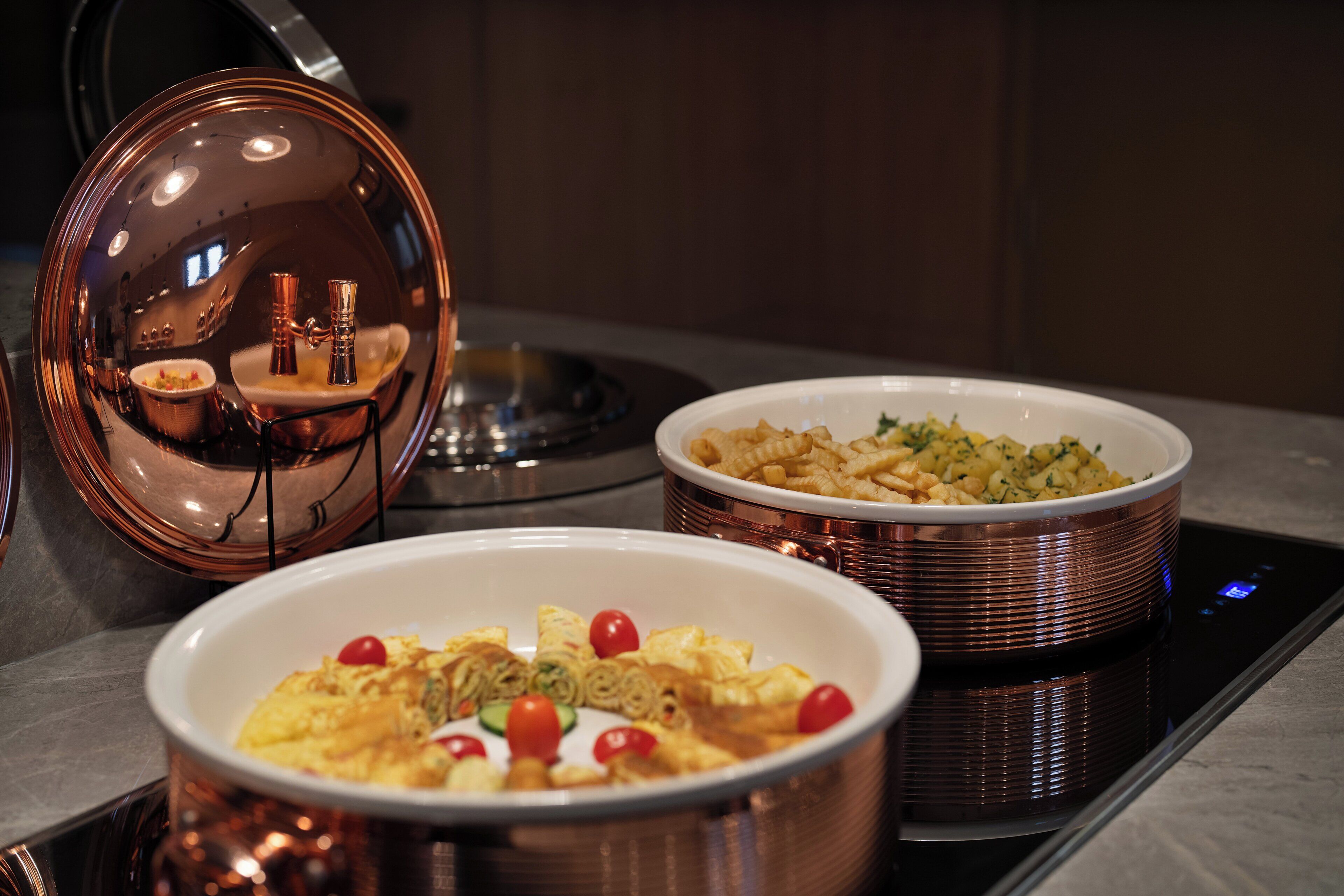 Una cocina moderna con electrodomésticos de acero inoxidable y utensilios de cocina de cobre.