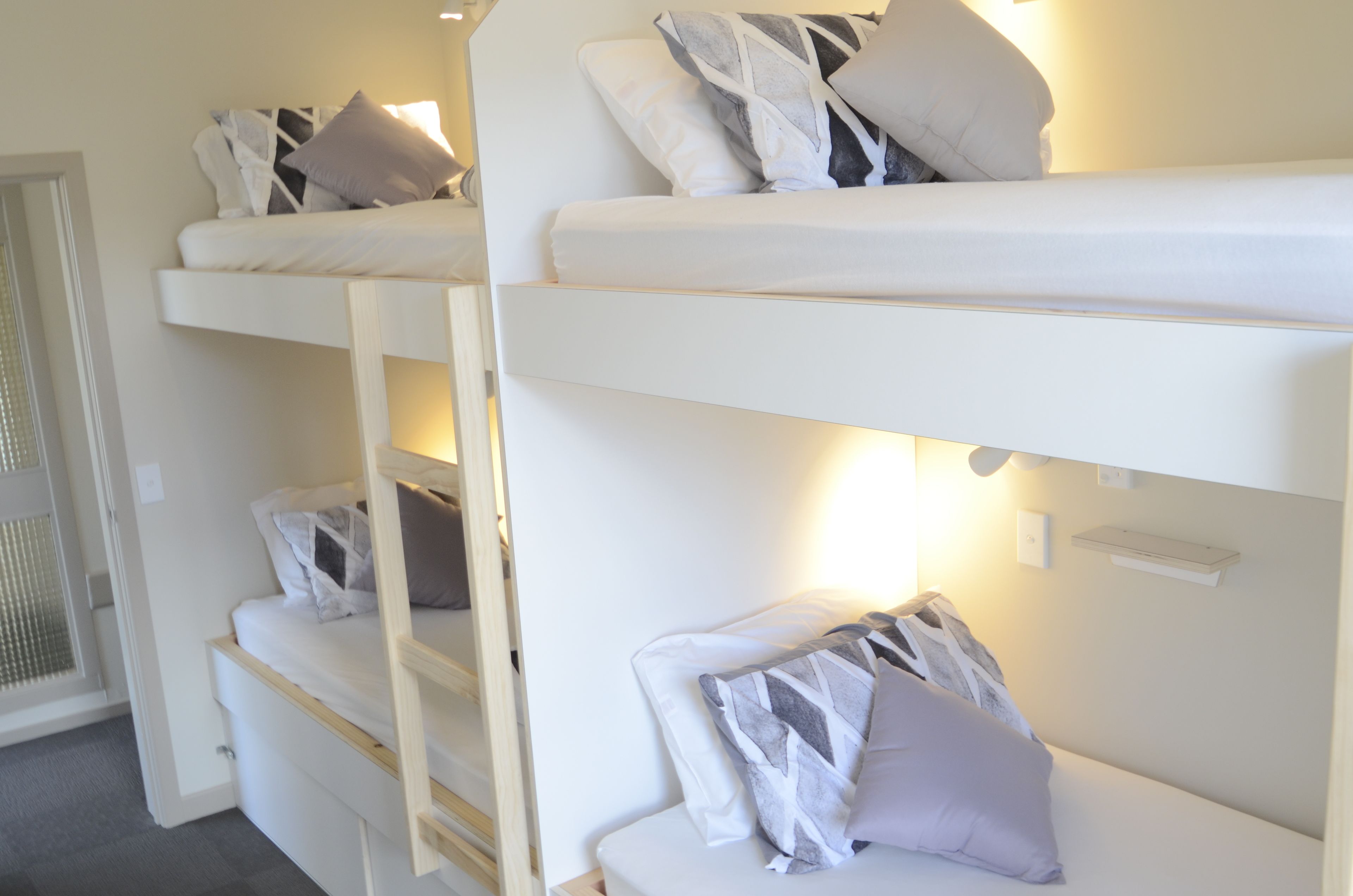 Ein Stockbett mit mehreren Etagen, jede mit Kissen und Kopfstütze.
