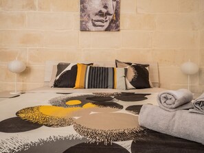 Ein Schlafzimmer mit Bett, Kissen, Decke und Handtuch.