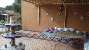 An outdoor seating area with a checkered bench, a round table, and a decorative fountain.