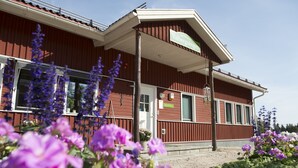Punaisella julkisivulla varustettu rakennus, jonka yläpuolella on kyltti, jossa lukee ”Valbergssängen”.