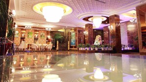 A spacious lobby with a reflective floor, elegant chandeliers, and a variety of seating arrangements. - Lvgu Hotel Yiwu (Jinhua)