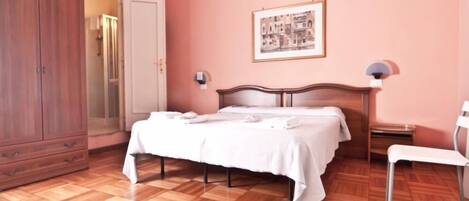 Una camera da letto con un letto, un armadio, una sedia e un comodino.