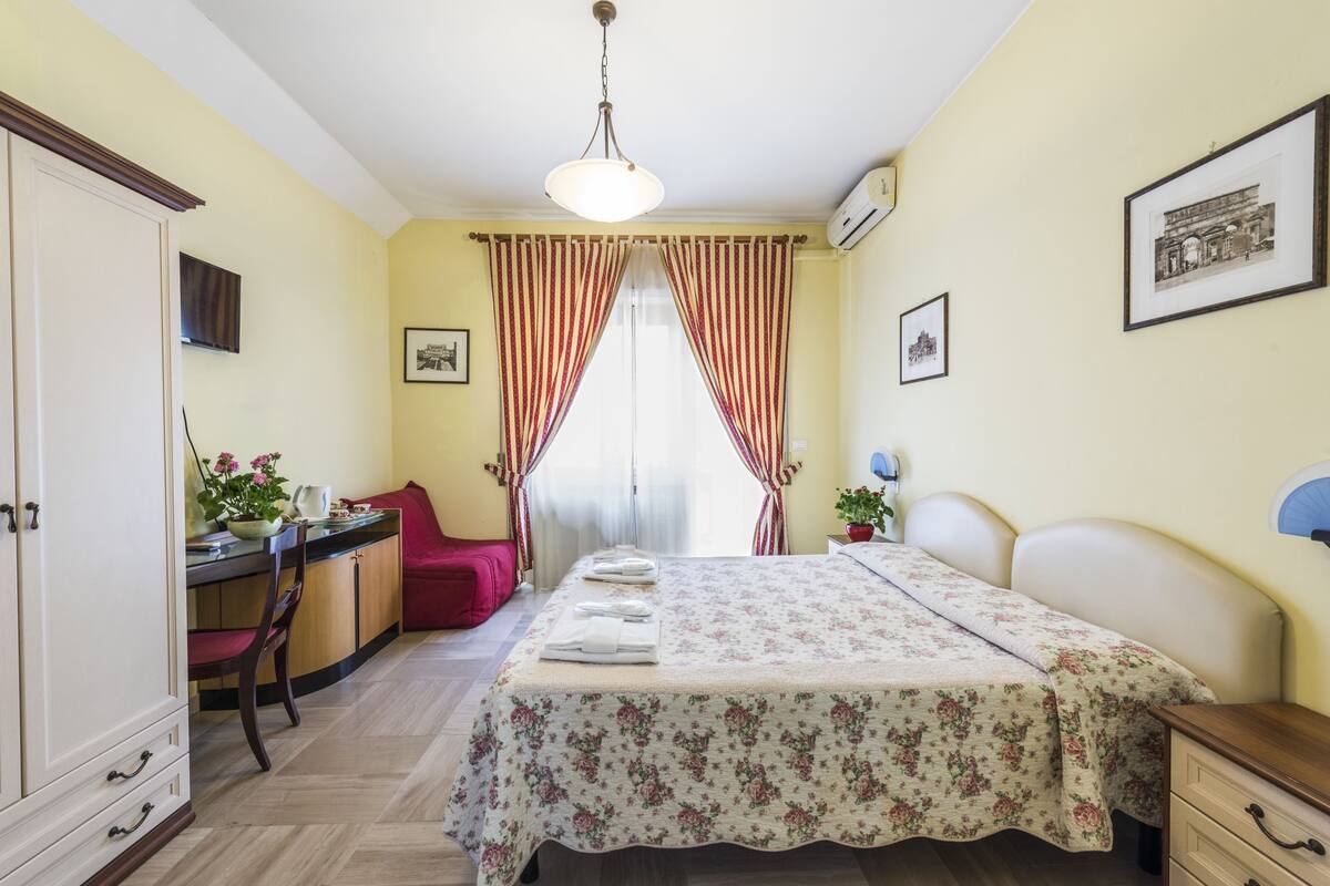 Ein Schlafzimmer mit Bett, Schreibtisch, Stuhl und Kleiderschrank.