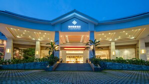 A hotel entrance with a modern design, featuring a prominent sign and a well-lit facade. - Yihohotel Xiang'An Xiamen (Xiamen)