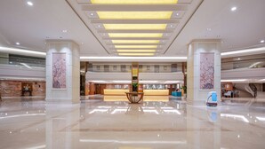A spacious lobby with a reception desk, a robot, and a large chandelier. - Yihohotel Xiang'An Xiamen (Xiamen)