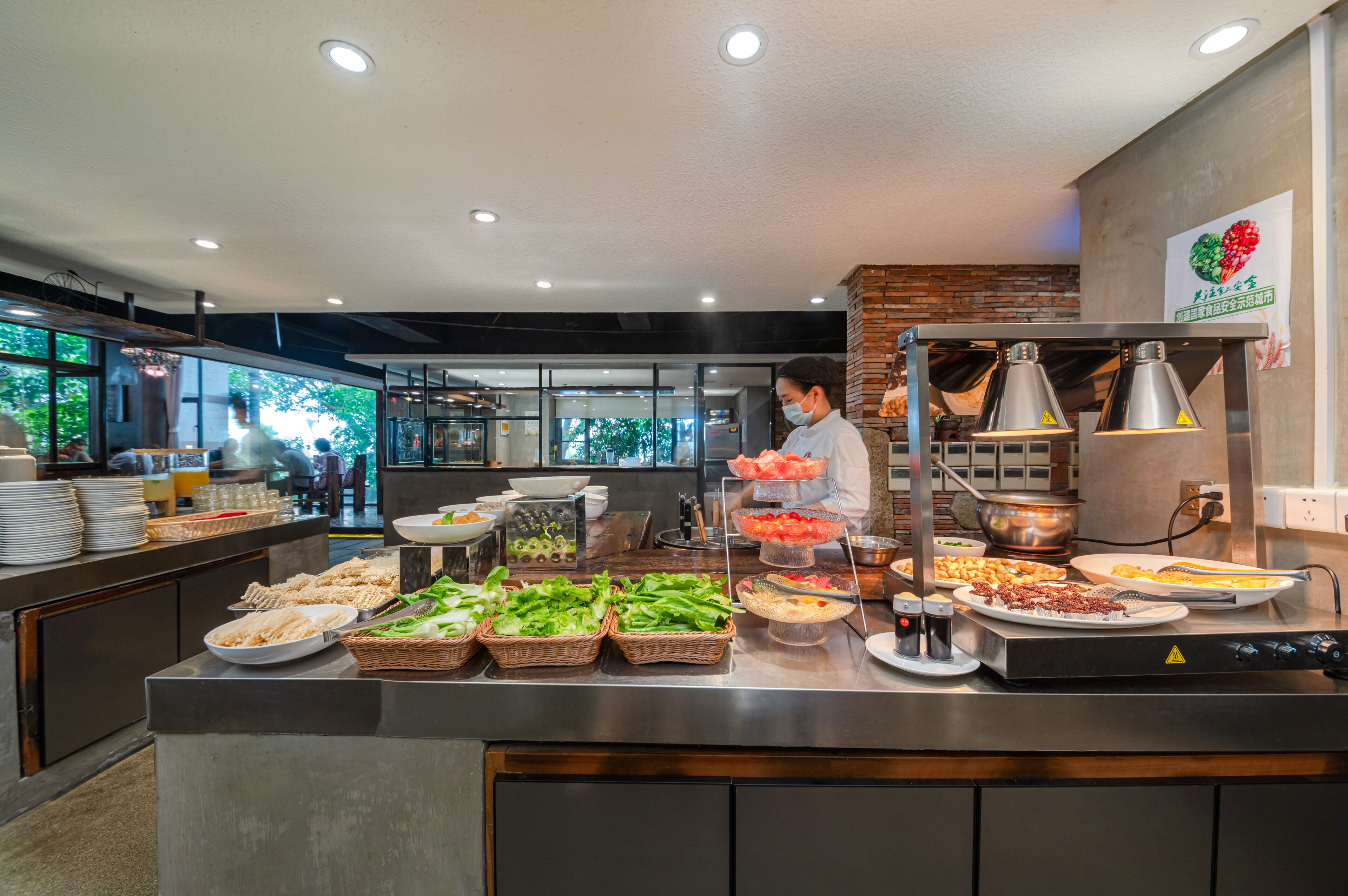 Un buffet con diversi piatti e uno chef che cucina.
