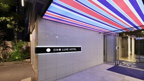 The exterior of the Japanese LUXE HOTEL with a modern design, including a striped ceiling and a clear entrance. - Nipponbashi LUXE Hotel (Osaka)