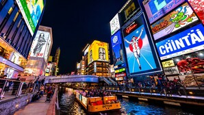 A busy urban river scene with illuminated billboards and a bridge. - Nipponbashi LUXE Hotel (Osaka)