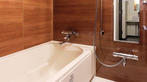 Bathroom features a large bathtub, wooden panel design, and a chrome faucet.