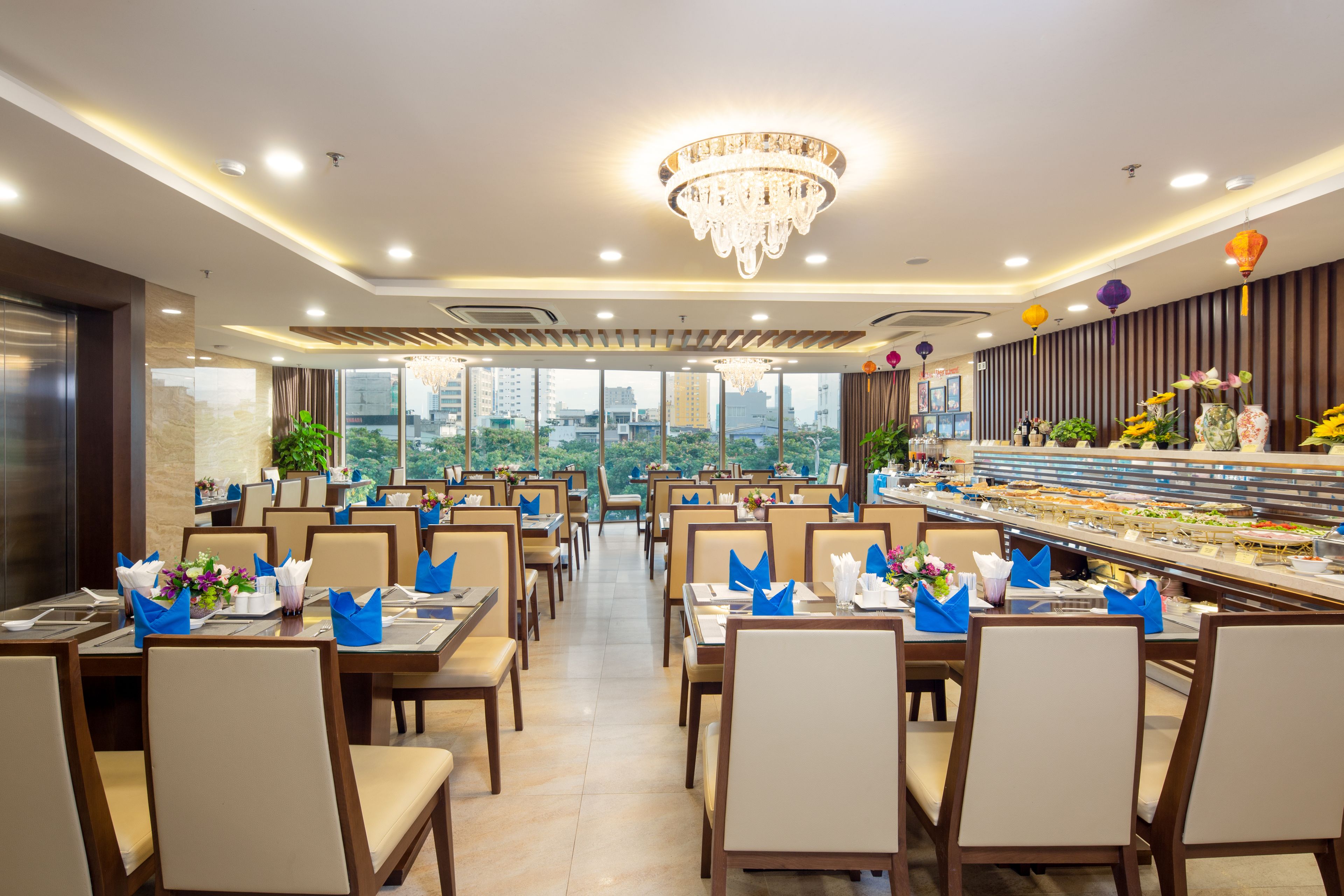 A restaurant with multiple dining tables, chairs, and a buffet area.