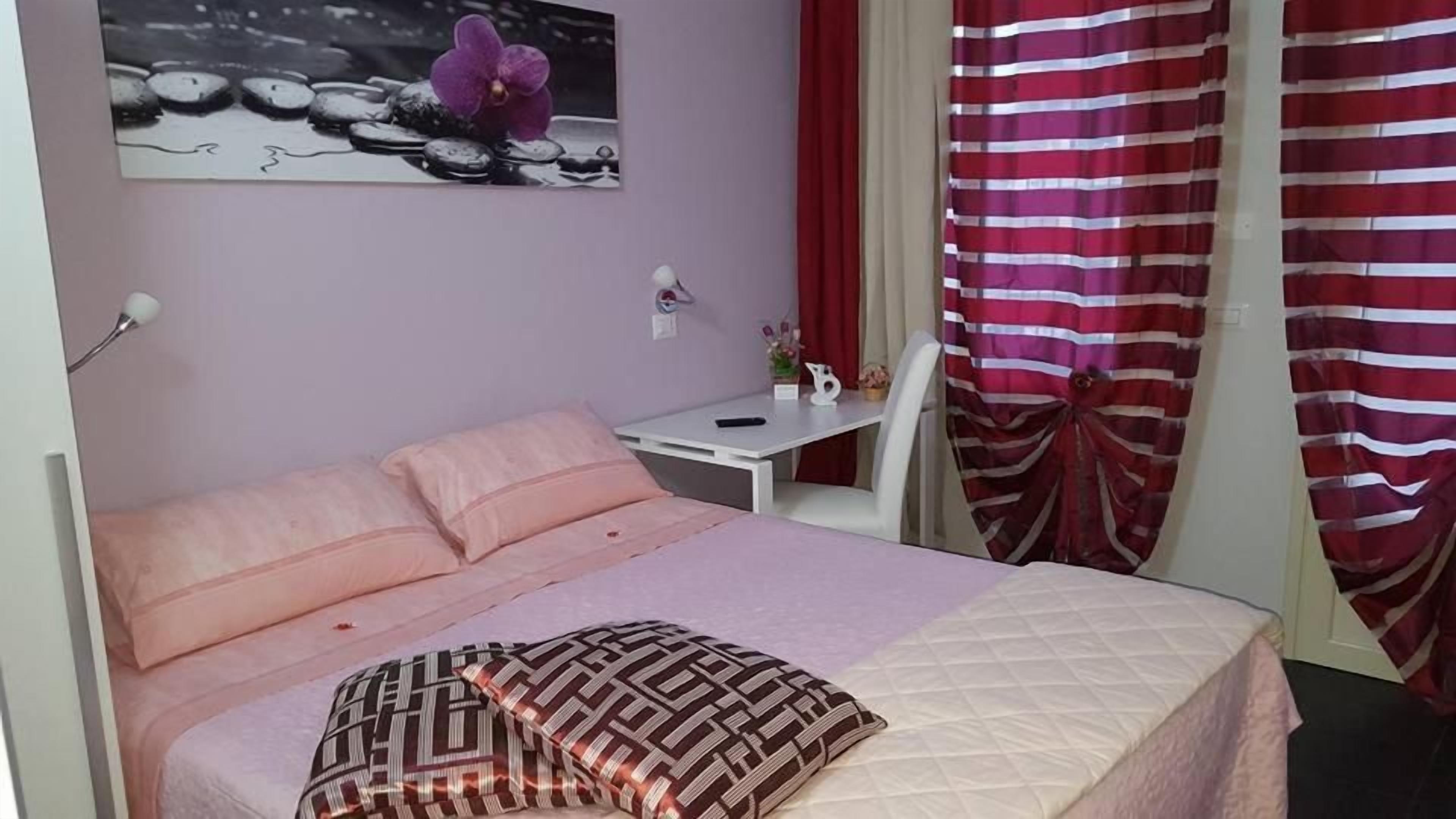 Un dormitorio con cama, escritorio y silla.