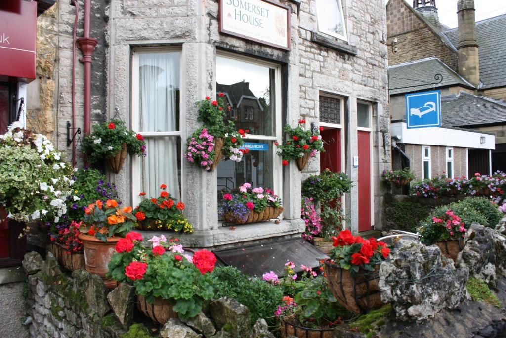 A stone building with a sign reading 'Somerset House' and a blue sign indicating a parking space.