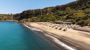 On the beach, black sand, sun loungers, beach umbrellas