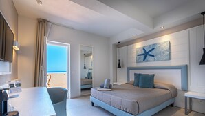 Una habitación de hotel moderna con una cama, un escritorio y vista al mar.