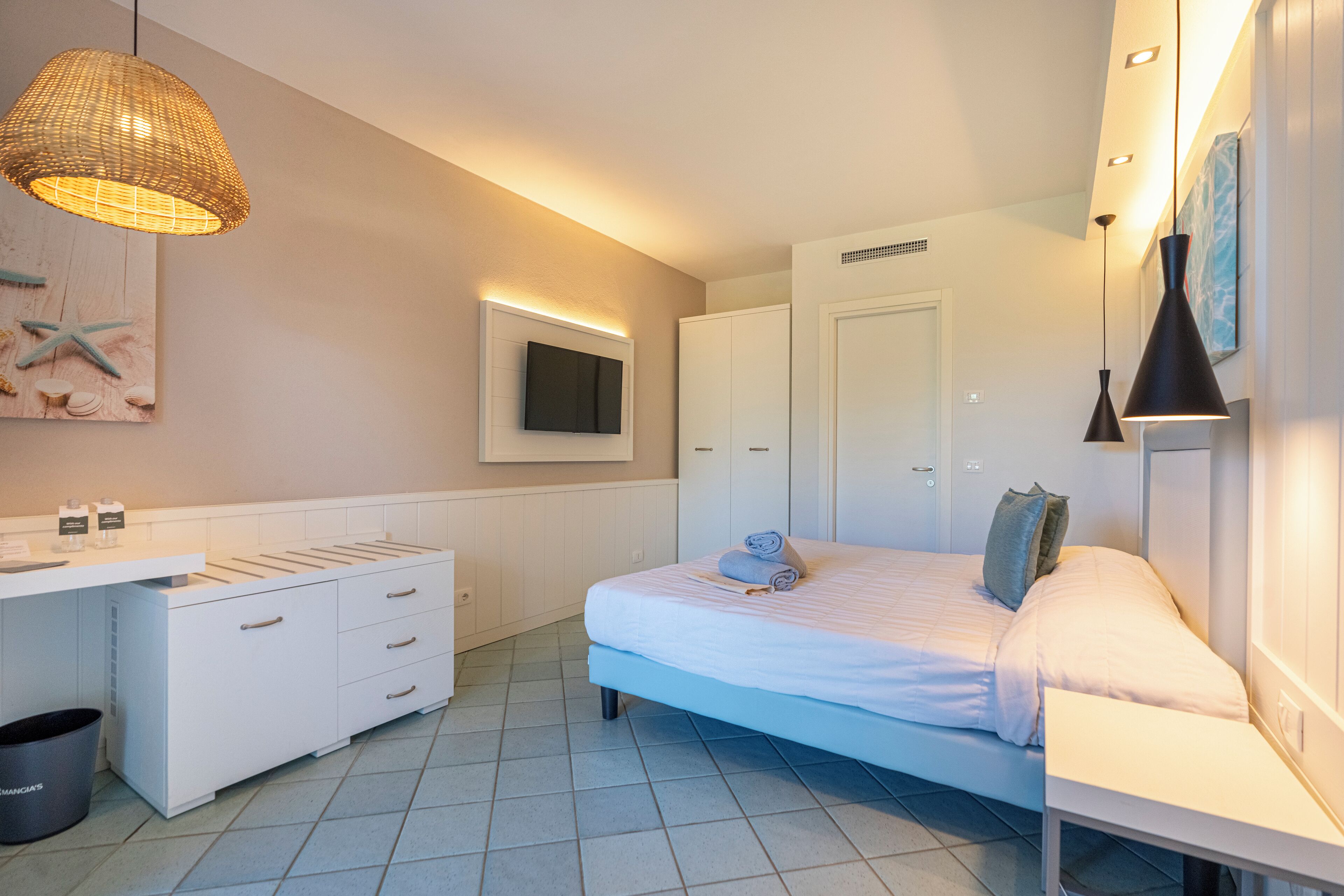 A modern bedroom with a bed, bedside table, and a built-in wardrobe.