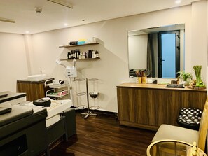Un cabinet dentaire moderne, avec un comptoir d’accueil en bois, un fauteuil dentaire et un présentoir contenant divers articles.