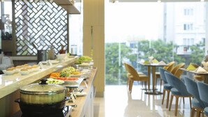Un espace buffet proposant une variété de plats et une grande marmite posée sur le comptoir.