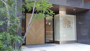 The exterior of the RE Hotel with a modern design, a glass entrance, and a visible parking sign. - RE HOTEL Tanimachi9chomeⅡ (Osaka)