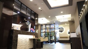 A modern reception area with a marble counter, seating, and a decorative wall. - RE HOTEL Tanimachi9chomeⅡ (Osaka)