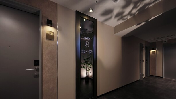 A modern hotel corridor with a digital display showing the floor number and direction. - RE HOTEL Tanimachi9chomeⅡ (Osaka)