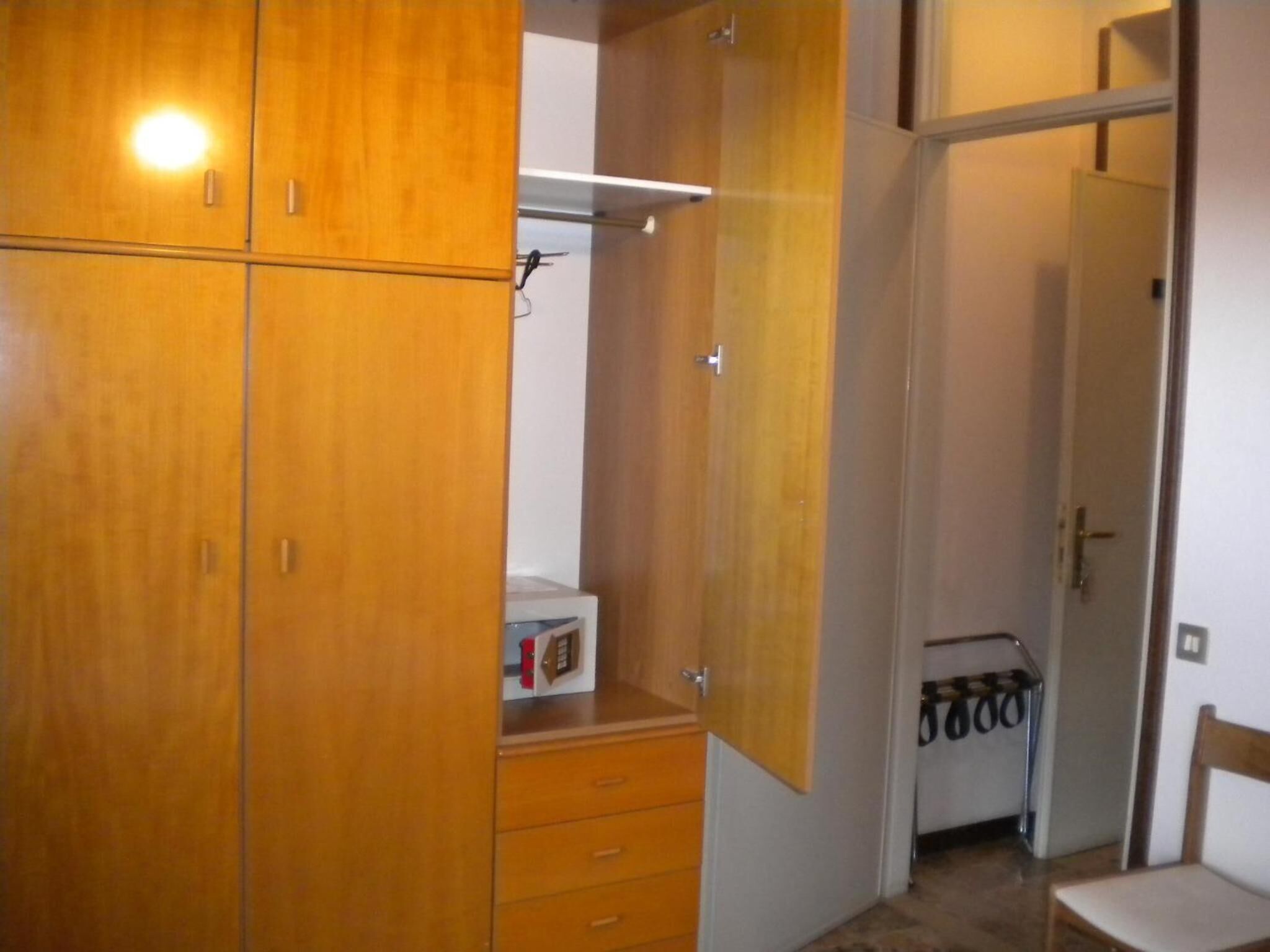 Ein Zimmer mit Holzschränken, einem kleinen weißen Schrank und einem Stuhl.