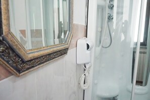 A bathroom with a glass shower enclosure, a white toilet, and a mirror with an ornate frame. -  La Boheme SMART Hotel (Turin)