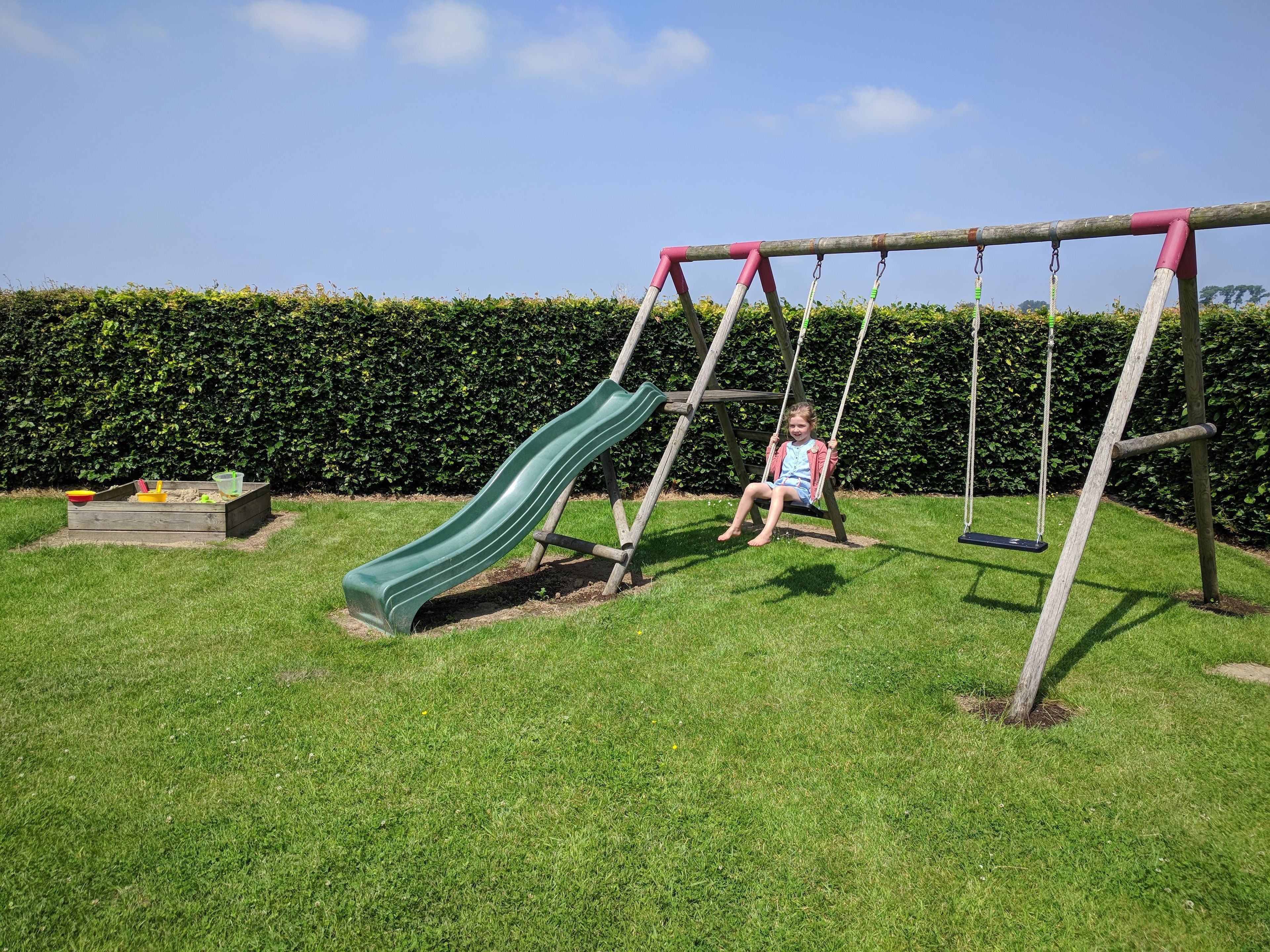 A playground with a slide and swings.