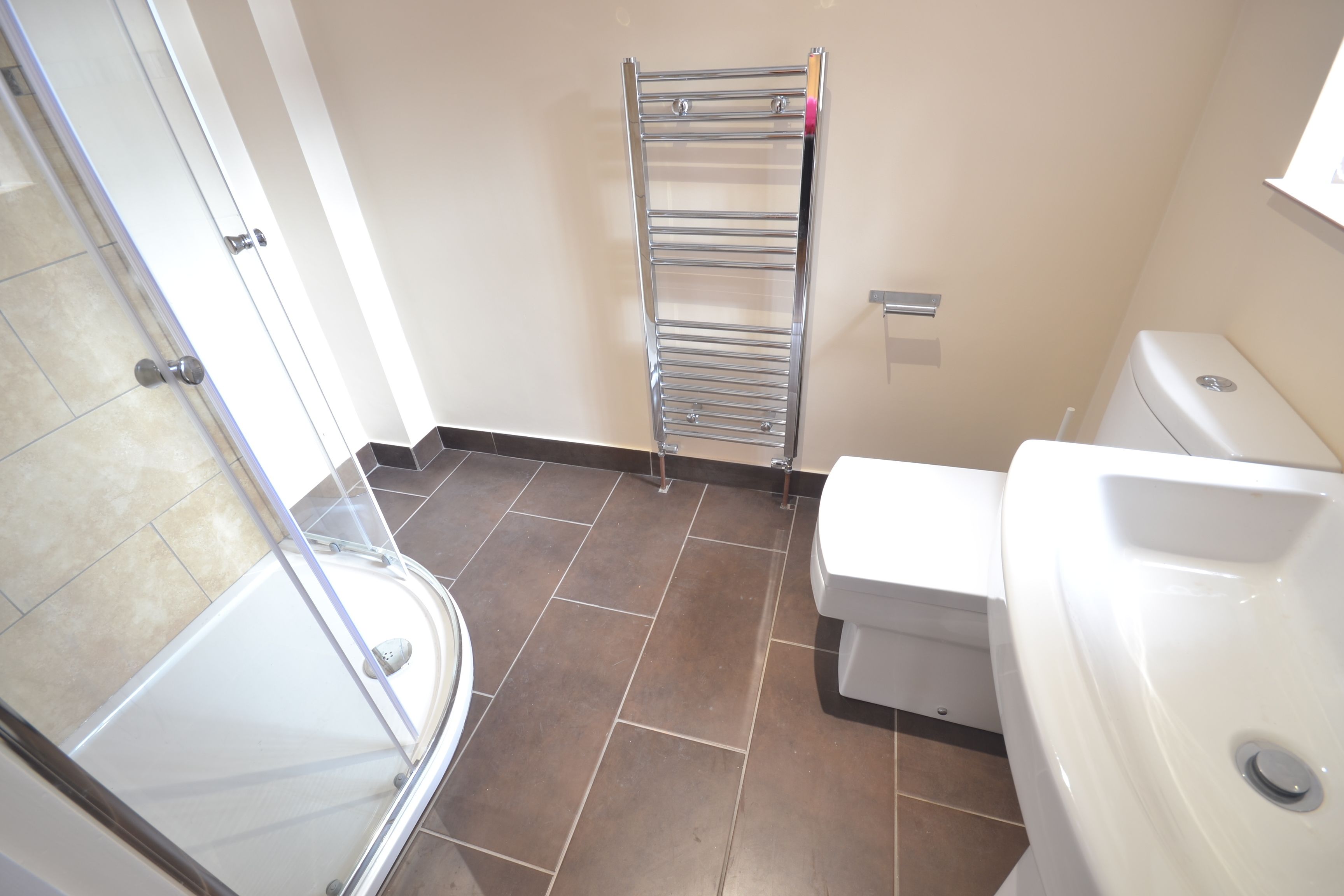 A bathroom with a shower, toilet, and sink.