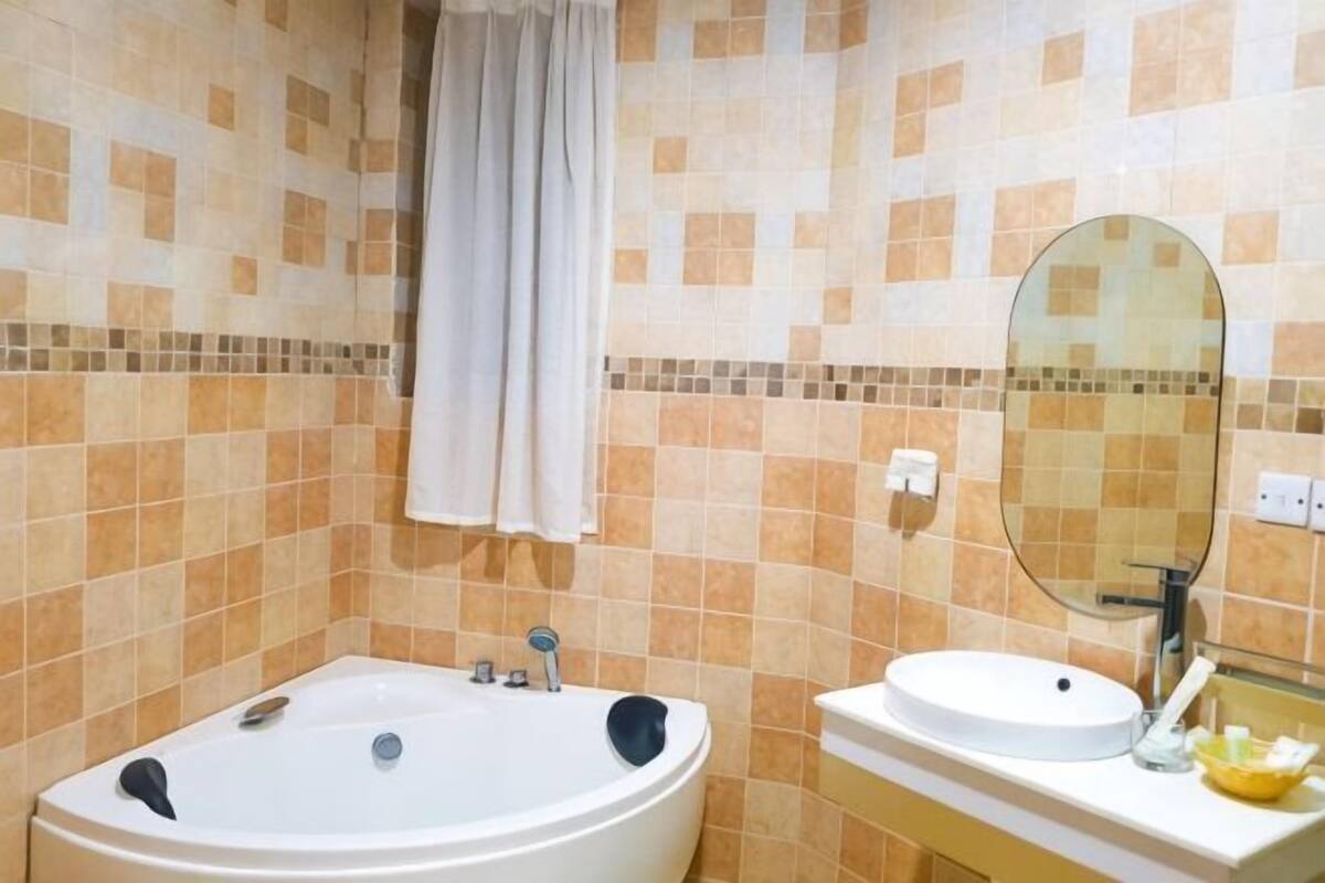 Un baño con bañera, lavabo y espejo.
