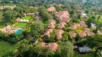 Vista aérea de una zona residencial con casas, piscina y abundante vegetación.