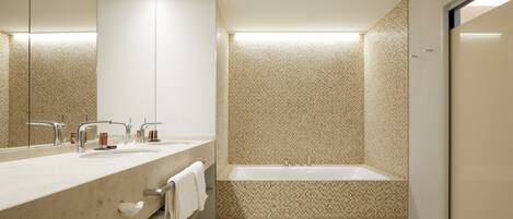 A modern bathroom with a double sink vanity, a large mirror, and a freestanding bathtub.
