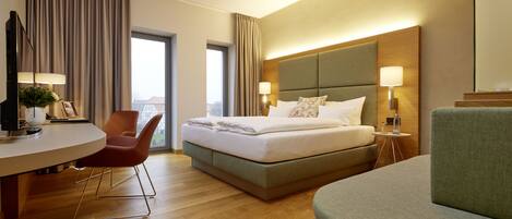 Una habitación de hotel con cama, escritorio, silla y sofá.