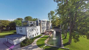 A modern building with a courtyard, a fountain, and a well-maintained lawn. - Hotel Rittergut Störmede (Geseke)