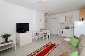 Apartamento, 1 quarto, terraço, vista parcial para o mar | Área de estar | TV de tela plana