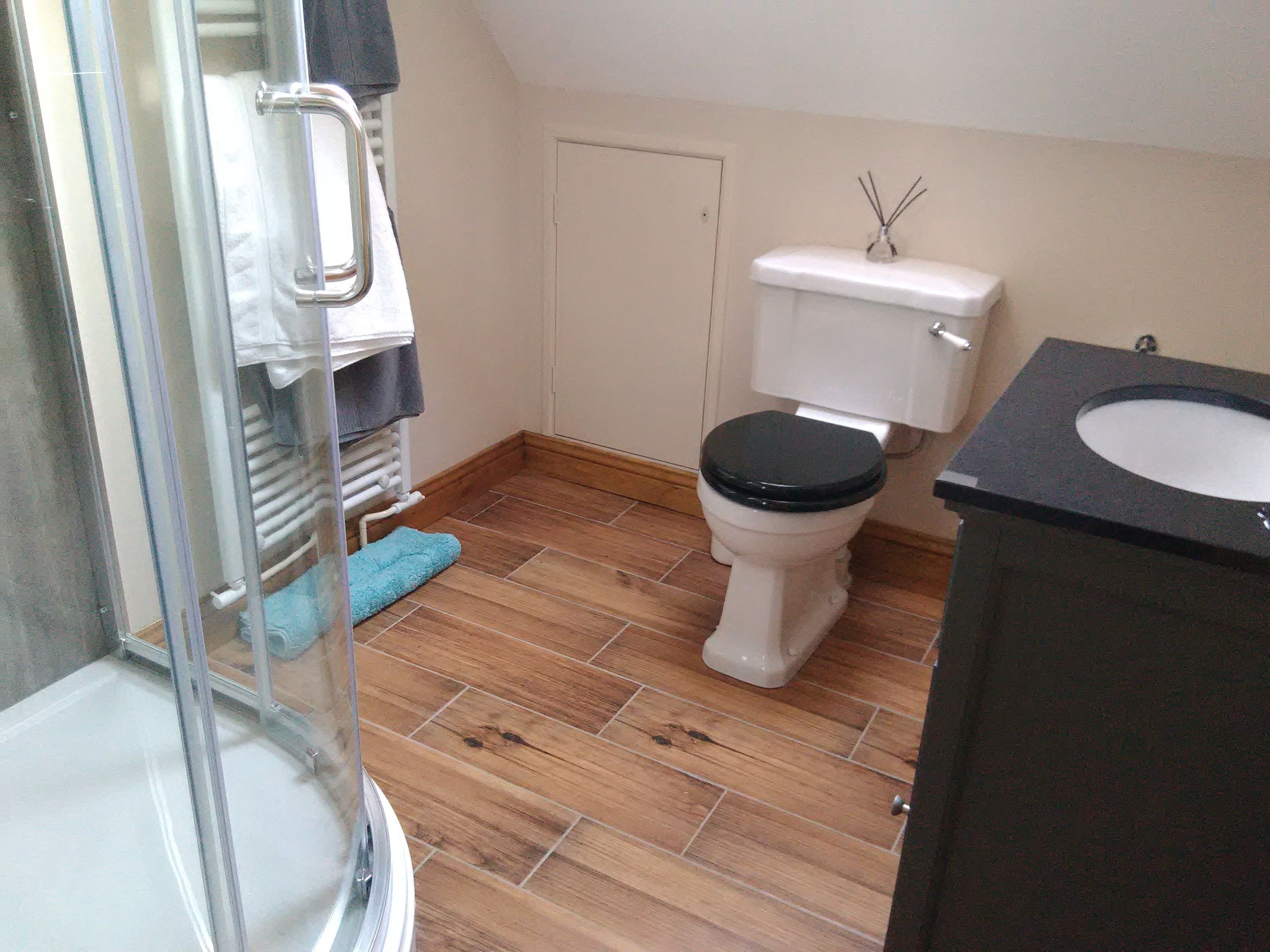 A bathroom with a toilet, sink, and shower area.